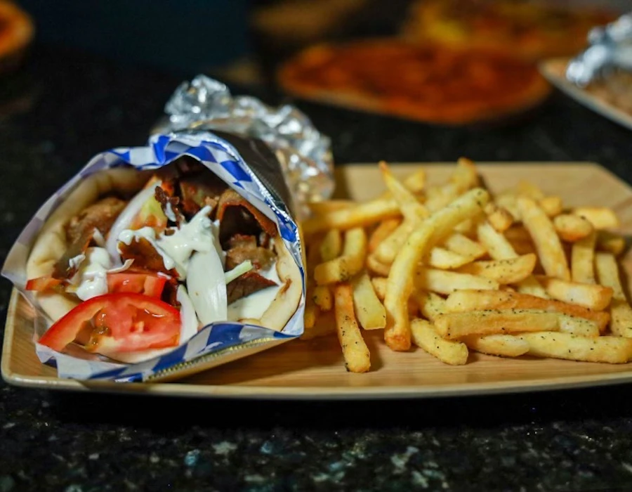 Classic gyro with spiced lamb and beef, tomatoes, onions, and tzatziki in a warm pita